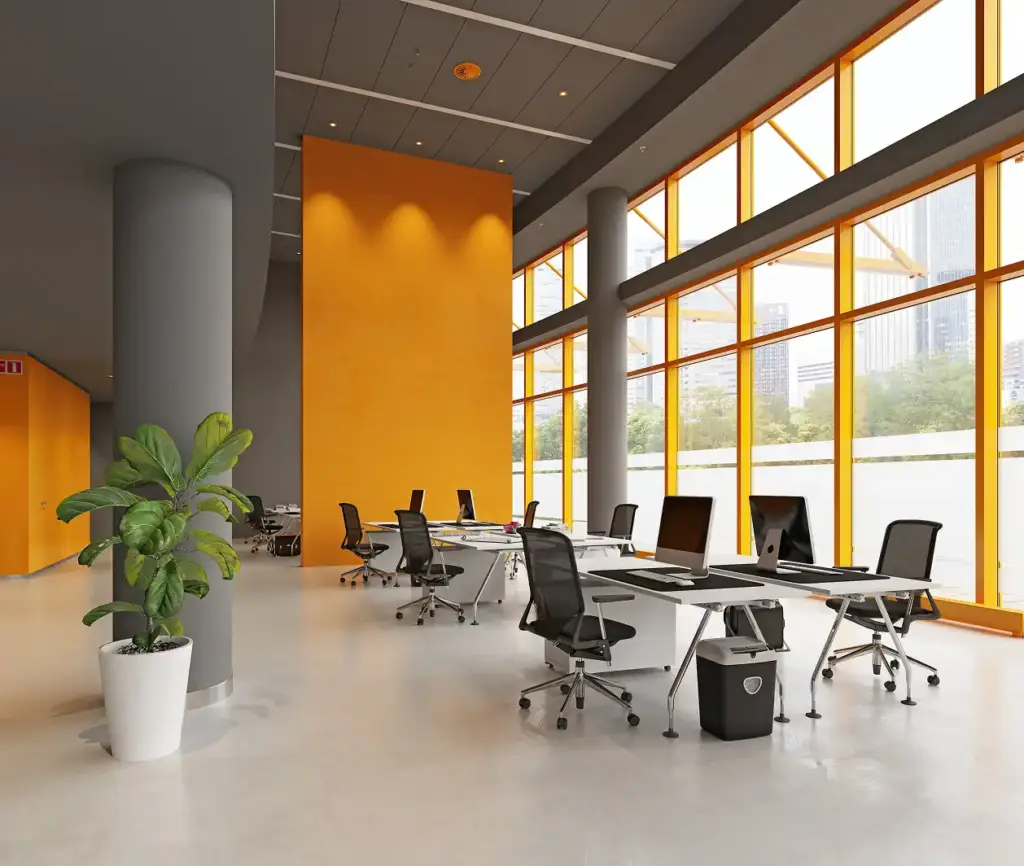 Ruime en heldere co-working met gele muren en grote vloer-tot-plafond ramen.